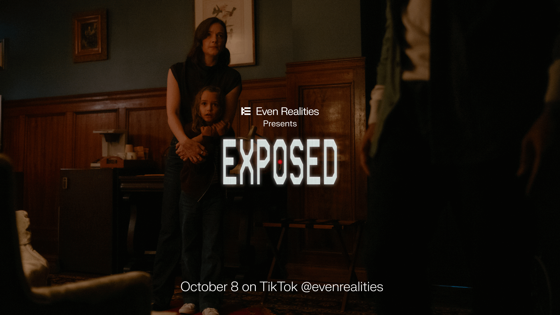 EXPOSED horror key art: a woman holds a child in a dim room opposite a shadowed figure.